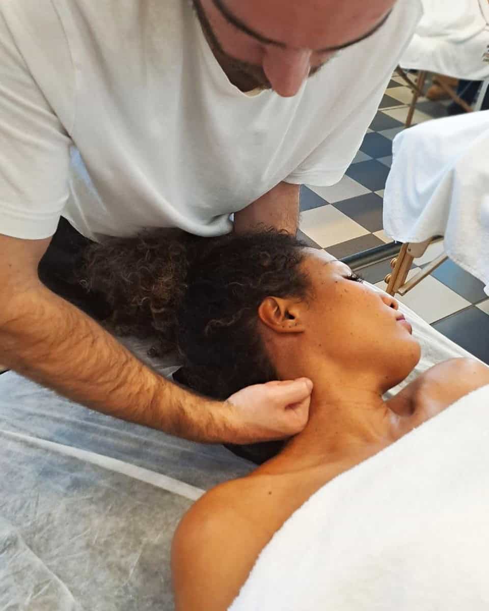 Massaggiatore professionista che esegue massaggi muscolari in ambito di formazione.